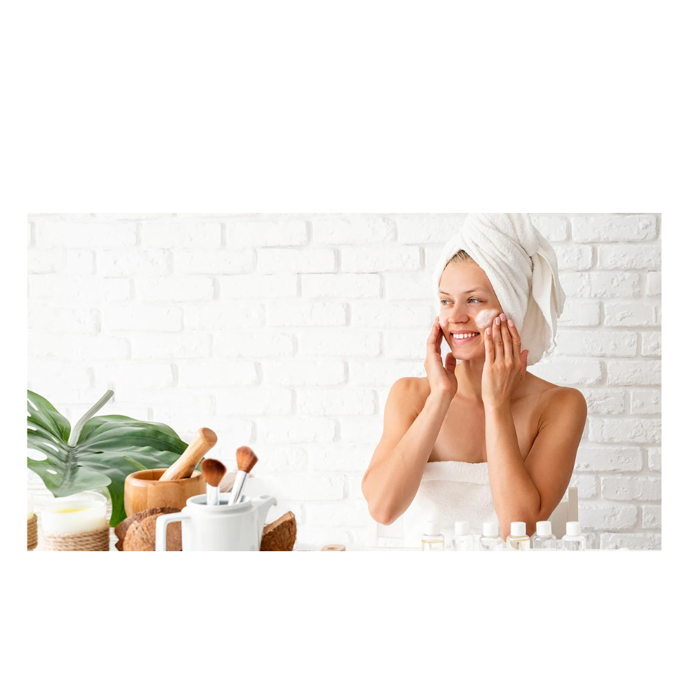 A woman in white towel sitting at table with plants.